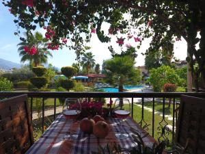 - une table avec des fruits et des verres à vin sur le balcon dans l'établissement Lale Apartments Fethiye, à Fethiye