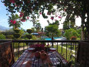 a table with fruit and wine glasses on a balcony at Lale Apartments Fethiye in Fethiye
