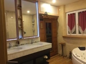 a bathroom with two sinks and a large mirror at La Découverte, Jacuzzi, Sauna, et Terrasse avec vue sur lac à la campagne entre Toulouse et Auch in Catonvielle +30 photos