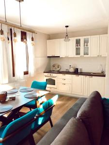 a living room with a table and chairs and a kitchen at Vikendica Rita in Risovac