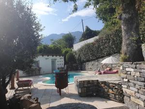 a swimming pool with a person sitting under an umbrella at maison de charme avec piscine et vue exceptionnelle in Scolca