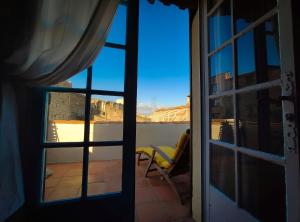 uma vista para um quarto com uma janela e uma cadeira em At Home in Arles em Arles