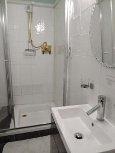 a white bathroom with a sink and a shower at Llanwrtyd Hall B&B Angelis Holistic Retreat in Llanwrtyd Wells