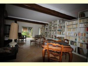 ein Zimmer mit einer Bibliothek mit einem Tisch und Stühlen in der Unterkunft Gîte de Minère in Estang