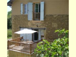 - un balcon avec une table et un parasol dans l'établissement Gîte de Minère, à Estang