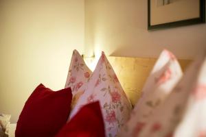 eine Gruppe von Kissen auf einem Bett in der Unterkunft Obereggerhof - Urlaub auf dem Bauernhof - Ferienwohnungen - Gitschberg Jochtal - Rio di Pusteria in Vals