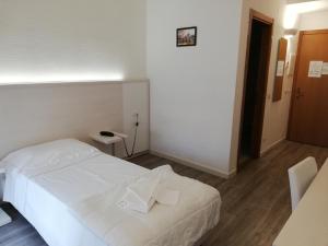 um quarto com uma cama branca num quarto em Eden Park em Marina di Montemarciano