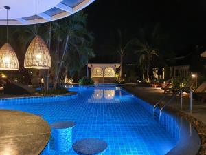 a swimming pool at night with lights at BLU PINE Villa & Pool Access - SHA Plus in Kata Beach