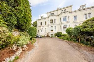a large white house with a driveway at Clifton Spacious 3 Bed Apt & Parking - Simplycheckin in Bristol