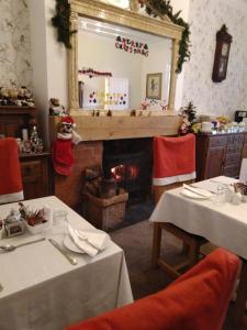a dining room with a fireplace and a christmas decorations at Llanwrtyd Hall B&B Angelis Holistic Retreat in Llanwrtyd Wells