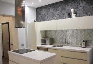 a white kitchen with a sink and a microwave at Central Area Apartments in Kyiv