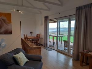 a living room with a couch and a table and a balcony at Mysthill Farm cottages in George
