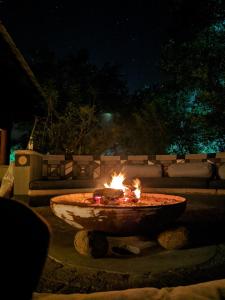 a fire pit in a yard at night at Bed in the Bush - Tingala Lodge in Phalaborwa
