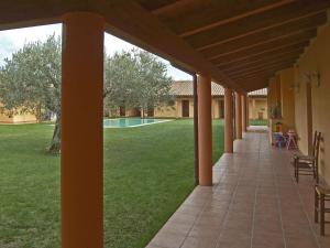 a patio with a view of a yard with a pool at Su Massaiu in Turri