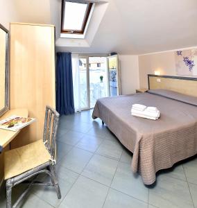 um quarto com uma cama, uma mesa e uma cadeira em Hotel Doria em Bellaria-Igea Marina