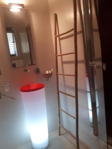 baño con escalera y taburete rojo en Suite Amnesia, en Mesagne