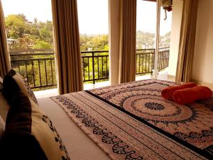 a bedroom with a bed with a view of a balcony at Jaye's Homestay in Kandy