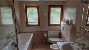 a bathroom with a tub and a toilet and a sink at Dworek nad Potokiem in Karpacz +42 photos