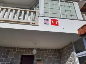 a sign on the side of a building with a balcony at Apartamentos Barrosa in Portonovo