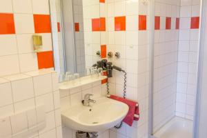 W łazience znajduje się umywalka i lustro. w obiekcie Schanzenstern Altona GmbH w mieście Hamburg
