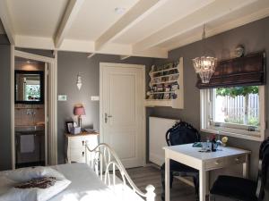 a bedroom with a bed and a table and a kitchen at Bed & Breakfast De Schuur Inn in Numansdorp