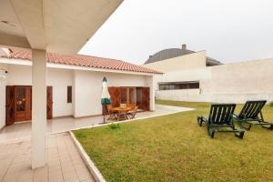 due sedie sedute su un prato di fronte a una casa di Vivenda Mar e Terra ad Apúlia