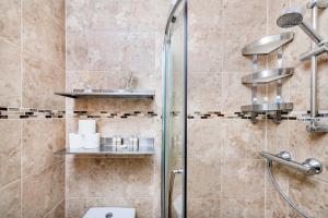 La salle de bains est pourvue d'une douche avec une porte en verre. dans l'établissement Soho Central Apartments, à Londres