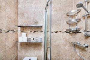 a bathroom with a shower with a glass door at Soho Central Apartments in London