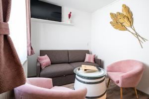 a living room with a couch and pink chairs at Winzerhof Lentsch in Jois