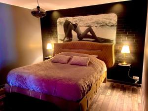 a woman laying on top of a bed in a bedroom at Suite avec Jacuzzi et Sauna Privée in Évreux