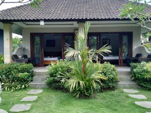 a house with a porch and some plants at Putu's Paradise Guesthouse in Ubud