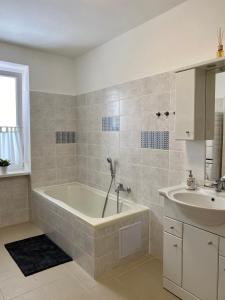 a bathroom with a bath tub and a sink at Apartmán Linda in Abertamy