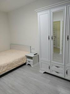 1 dormitorio con cama, tocador y espejo en 1-к кв ж/м Радужный en Odesa