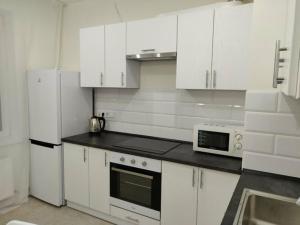 uma cozinha com electrodomésticos brancos e armários brancos em 1-к кв ж/м Радужный em Odessa