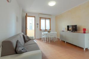 ein Wohnzimmer mit einem Sofa, einem TV und einem Tisch in der Unterkunft Appartamenti Angelica 21 in Pisa