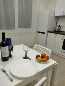 einen Tisch mit einer Schale Obst und einer Flasche Wein in der Unterkunft 1-к кв ж/м Радужный in Odessa