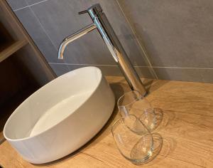 a sink and two wine glasses on a counter at B&B Bij tante Teun in Naaldwijk