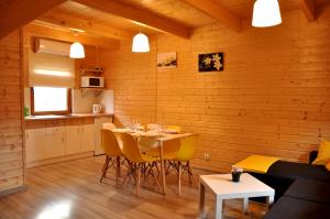 a dining room with a table and yellow chairs at Słoneczny Przystanek in Jarosławiec +40 photos