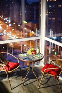 a table and two chairs on a balcony with a window at Allurapart Andersen in Kyiv