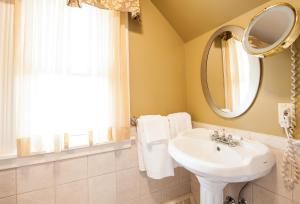W łazience znajduje się umywalka i lustro. w obiekcie Dundee Arms Inn w mieście Charlottetown