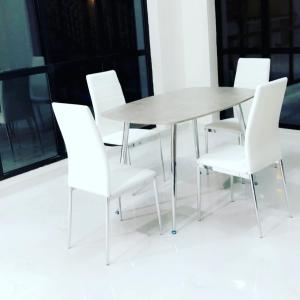 una mesa de comedor blanca y sillas blancas en una habitación en فيلا بلاتنيوم اند كي ام, en Unaizah