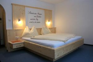 a bedroom with a bed with a sign on the wall at Gästehaus Pürstl-Kocher in Schladming