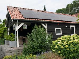 a black house with a solar panel on its roof at Bed & Breakfast De Schuur Inn in Numansdorp +9 photos