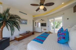 - une chambre avec un lit et un ventilateur de plafond dans l'établissement Casa Santosha, à Isla Mujeres