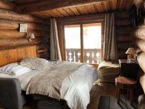 um quarto com uma cama num chalé de madeira em Chalet Le Ranch em Les Deux Alpes