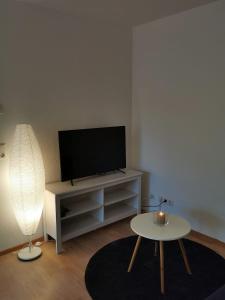 a living room with a flat screen tv and a table at Ferienwohnung Birkental in Ebringen