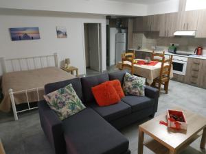 a living room with a blue couch and a kitchen at Adonis Apartment in Paphos