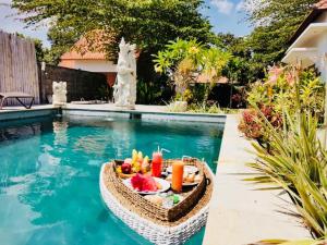 a tray of fruit in a basket next to a swimming pool at The Barari Villas in Pemuteran