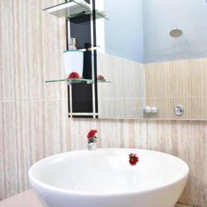 a bathroom with a white sink and a mirror at The Barari Villas in Pemuteran