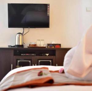 a bedroom with a flat screen tv on a bed at The Barari Villas in Pemuteran